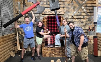 Group celebrating a party with foam axes at Dungeon Throwers in Madison