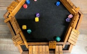 Six-sided wooden game board with dice, where you race to close out your side before others do. Play it at Dungeon Throwers in Madison.